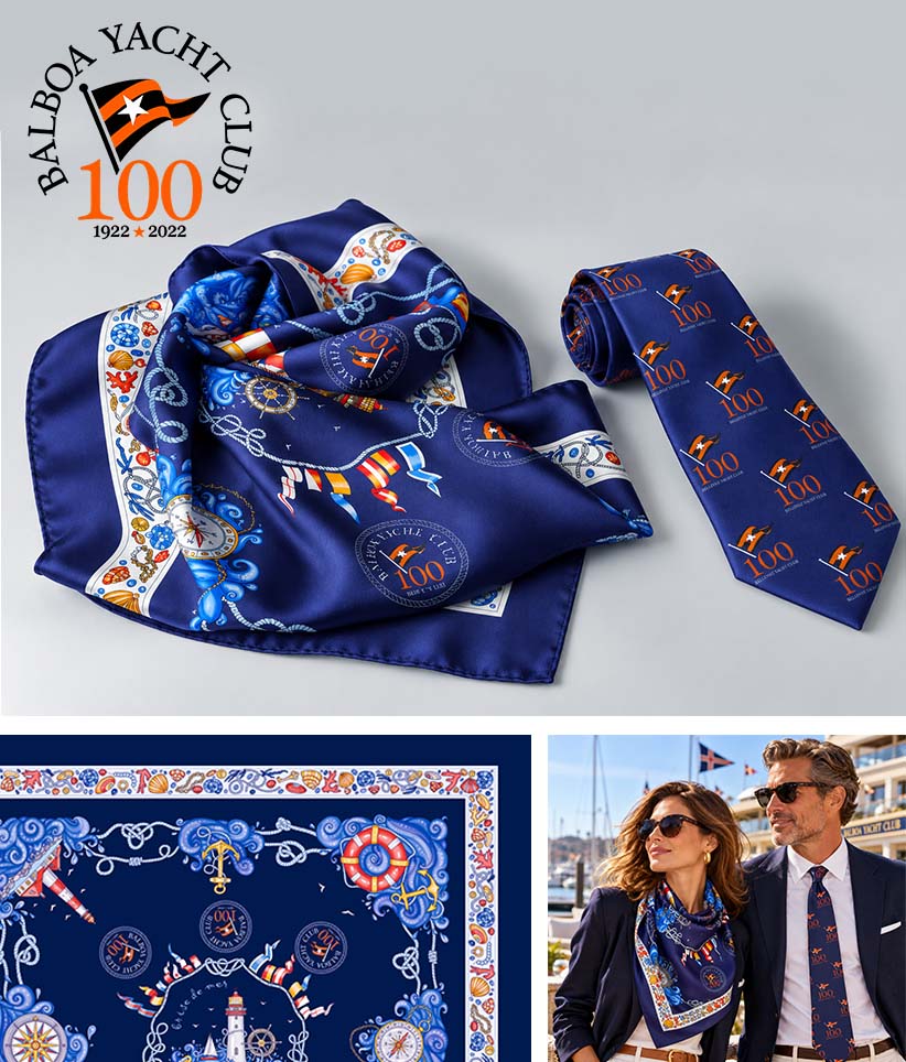 A luxury silk scarf and matching necktie set from Balboa Yacht Club, featuring a navy blue base with a colorful border and repeating '100 Years 1922-2022' logo print. The top half shows the scarf draped and the tie rolled on a light gray background with the club logo.